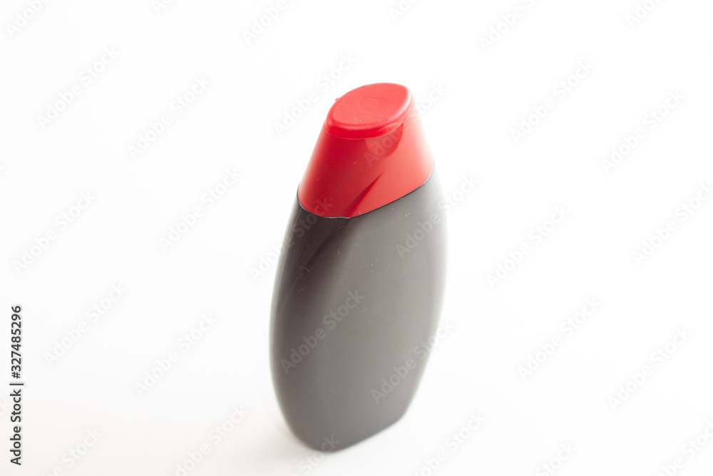 black empty bottle for liquid with red cap on a white background