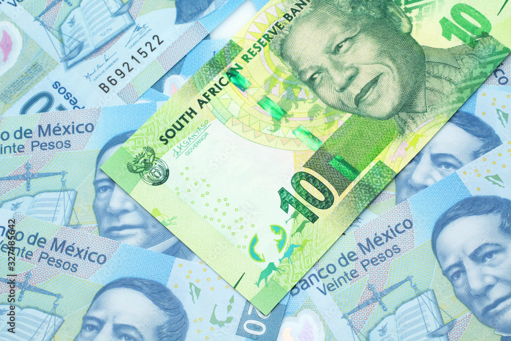 Fototapeta premium A close up image of a green ten rand bank note from South Africa in macro on a bed of Mexican twenty peso bank notes