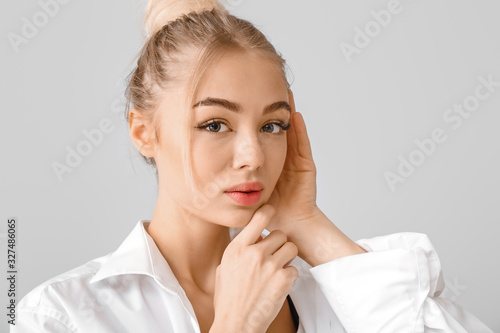Portrait of beautiful young woman on grey background