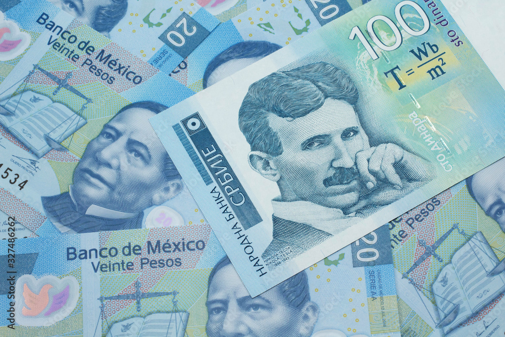Fototapeta premium A close up of a blue and white, one hundred Serbian dinar bank note on a background of Mexican twenty peso bank notes