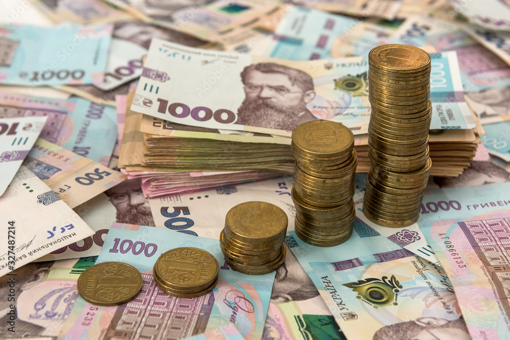 500 and 1000 bill ukraine money as background. gold coin lying on pile of grivna 500 and 1000 bill ukraine money as background. gold coin lying on pile of grivna