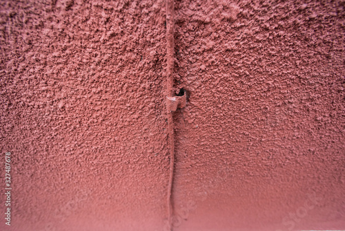 Wire on the pink facade of a cement wall