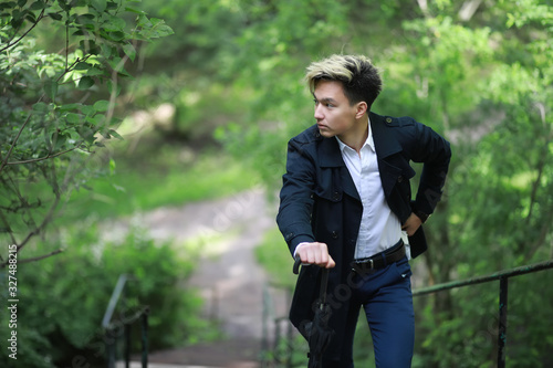 Spring rainy weather and a young man with an umbrella