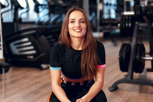 Fototapeta Woman fitness trainer portrait on a gym background