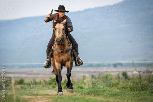Cowboy man riding horse shooting © Surachai