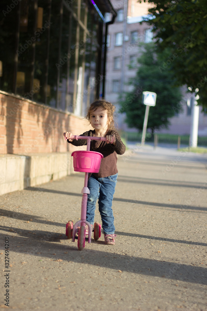 Yong kid girl ride on street with child scooter Yong kid girl ride on street with child scooter