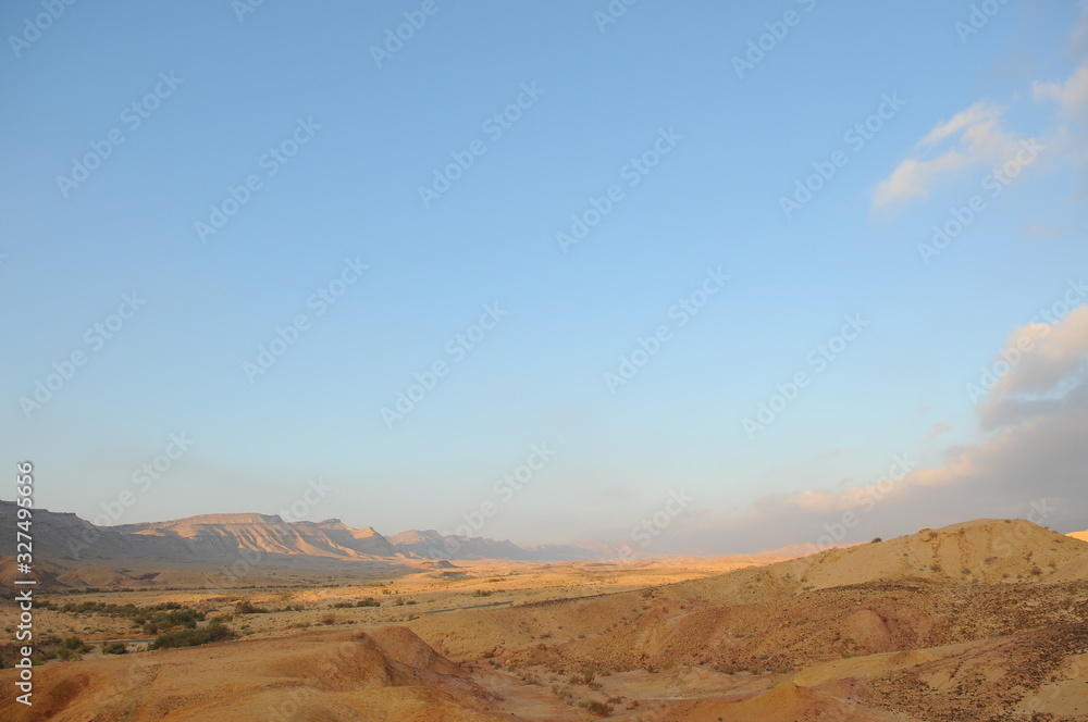 Fototapeta premium Desert landscape at sunrise. Hiking desert part of Israel National Trail. Negev desert . Valley. Colorful sands 