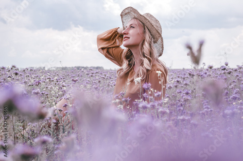 beautiful young pregnant woman in Hat in lavender field. blooming flowers