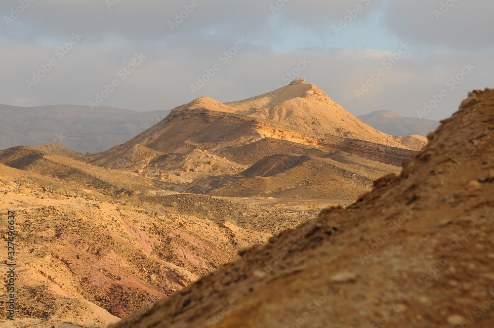 Desert landscape at sunrise. Hiking desert part of Israel National Trail. Negev desert . Valley. Colorful sands Desert landscape at sunrise. Hiking desert part of Israel National Trail. Negev desert . Valley. Colorful sands