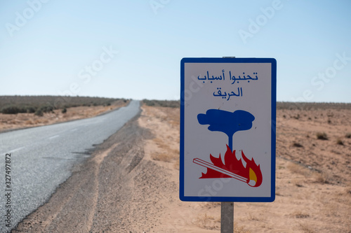 Warning sign of forest fires on a lonely road through the Moroccan Sahara