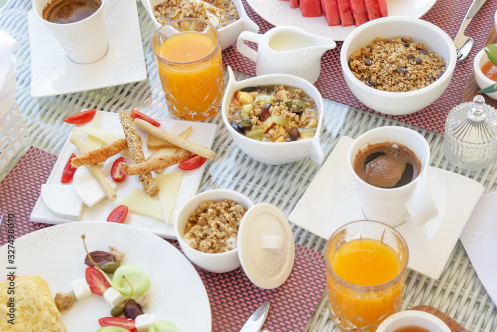 Beautifully arranged breakfast table with coffee, orange juice, pastry, fruits, cereals and eggs, top view Beautifully arranged breakfast table with coffee, orange juice, pastry, fruits, cereals and eggs, top view