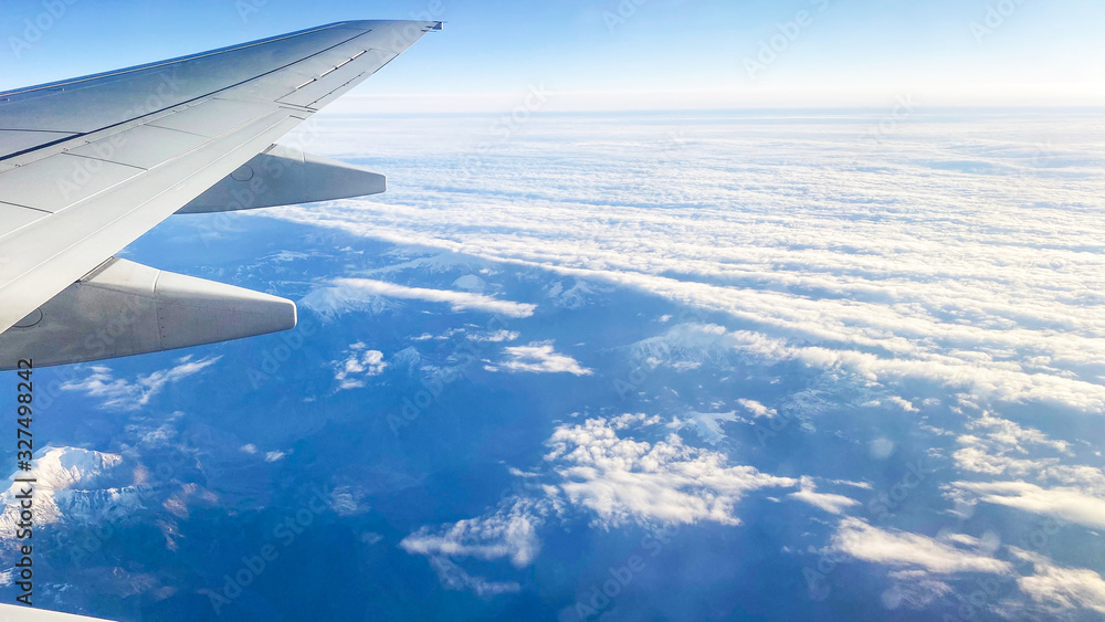 The view from the plane on the landscape from the window of the plane. Airplane wing flying above the clouds The view from the plane on the landscape from the window of the plane. Airplane wing flying above the clouds