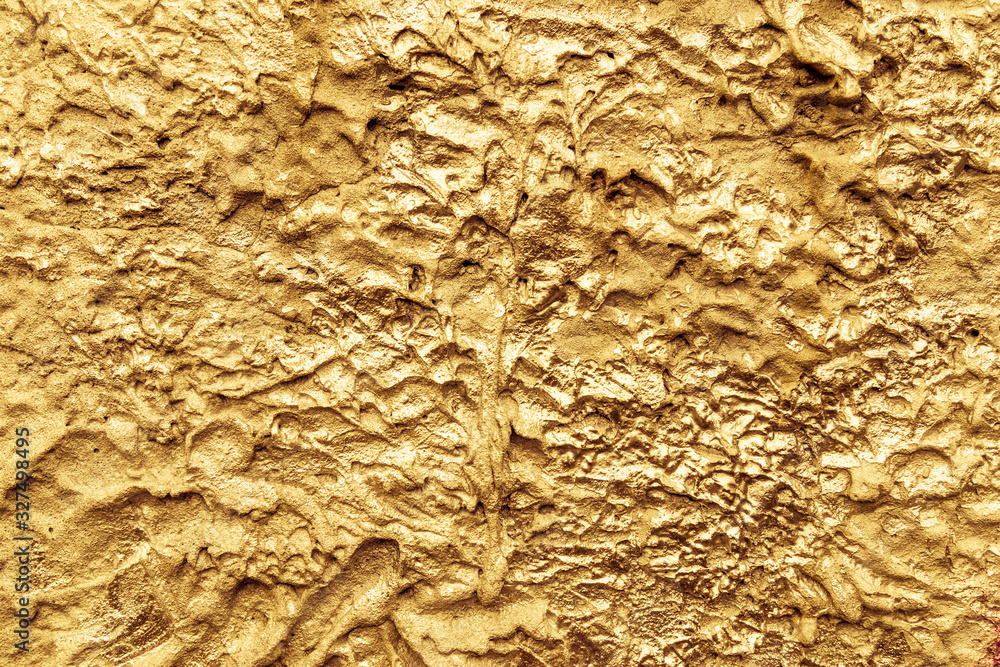 Abstract gold color painted on grunge rough surface of stucco concrete wall. Good for texture background and wallpaper Abstract gold color painted on grunge rough surface of stucco concrete wall. Good for texture background and wallpaper