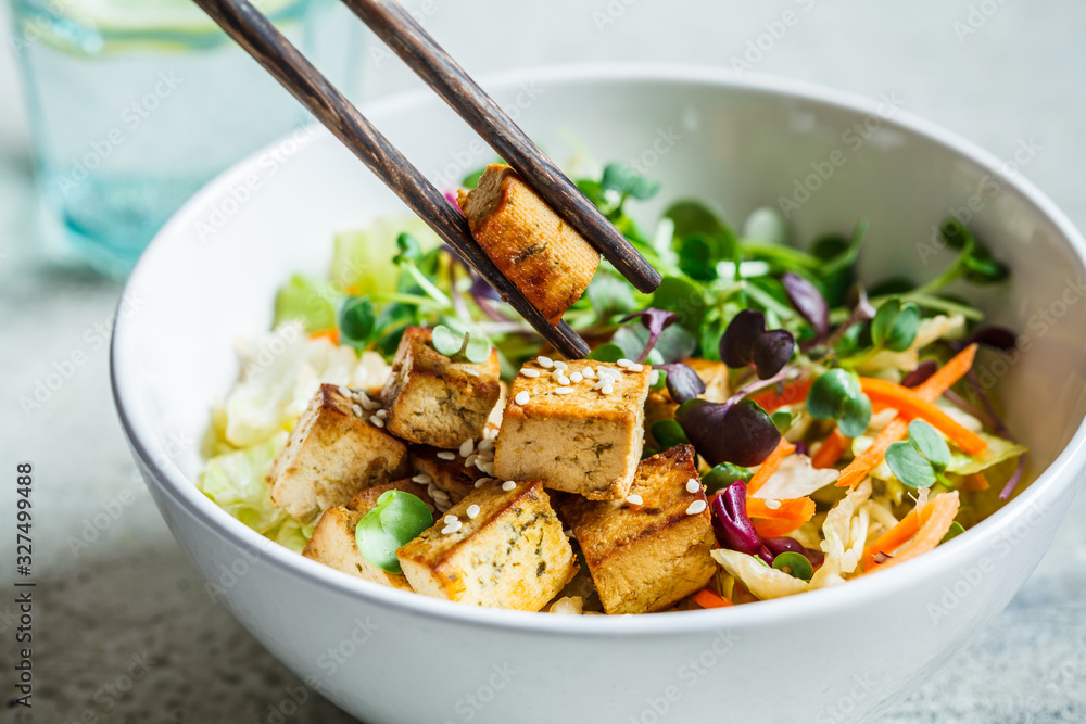 Fried tofu salad with seedlights and sesame seeds in white bowl. Vegan food, asian food concept. Fried tofu salad with seedlights and sesame seeds in white bowl. Vegan food, asian food concept.