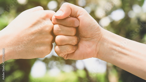 Teamwork in the nature concept,Which Young man fist bump  in the nature of bokeh background, © SASITHORN