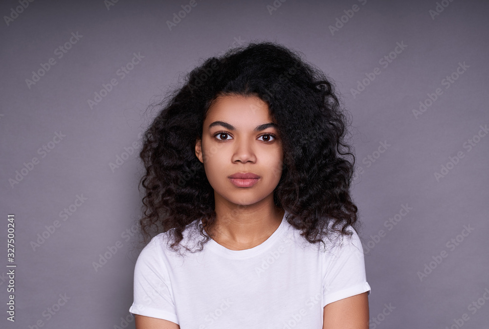 Fototapeta premium Portrait of a young calm girl African on a white background.