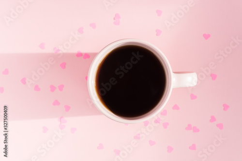 Top view of Pink cup pink background with scattered paper hearts. Love and care concept. Copy space for text, mock up