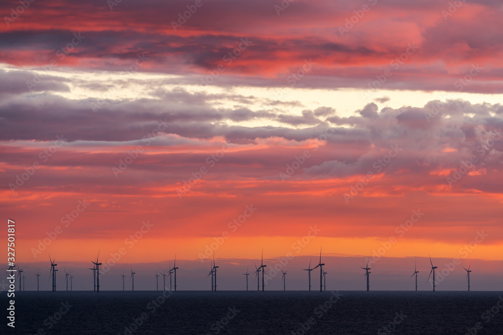 HORNSEA OFFSHORE WIND FARM, UK - 2016 JULY 12. Colorful clouds together with the wind farm at offshore. HORNSEA OFFSHORE WIND FARM, UK - 2016 JULY 12. Colorful clouds together with the wind farm at offshore.