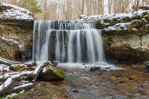 City Sigulda  Latvia. Waterfall in winter. White snow and trees. Travel photo.