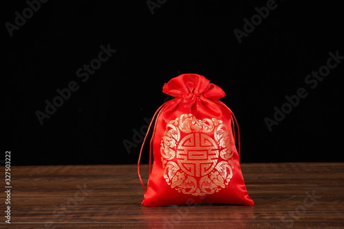 The traditional Chinese Red sachet is embroidered with a blessing pattern, indicating peace and blessing