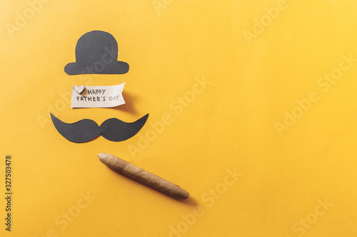 Father's day concept. funny moustache with hat and cigar on yellow background. flat lay, top view.