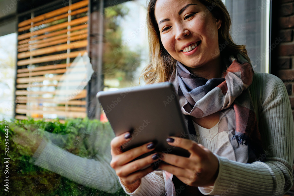 Close up of a Beautiful Asian woman looking at her tablet Close up of a Beautiful Asian woman looking at her tablet