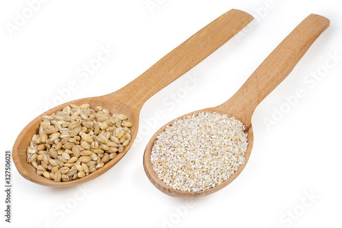 Two different barley groats in wooden spoons on white background
