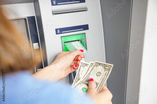 Woman using modern ATM nashine - cash withdrawal.
