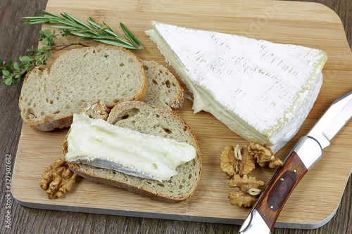 Fotografie tranche de brie et pain sur une planche à découper