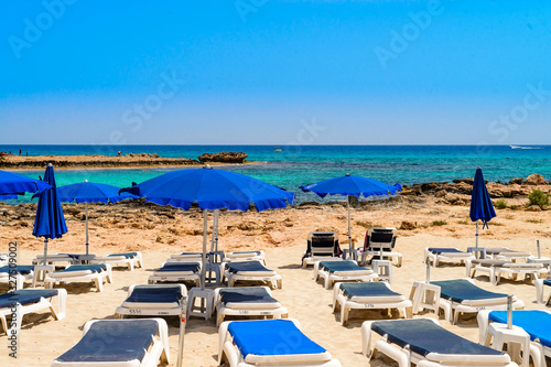 blue sunbeds and umbrellas on the famous cyprus beach nissi beach