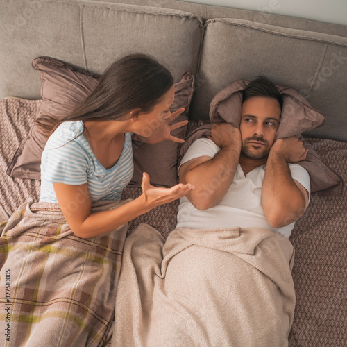 Young couple is arguing in bed.
