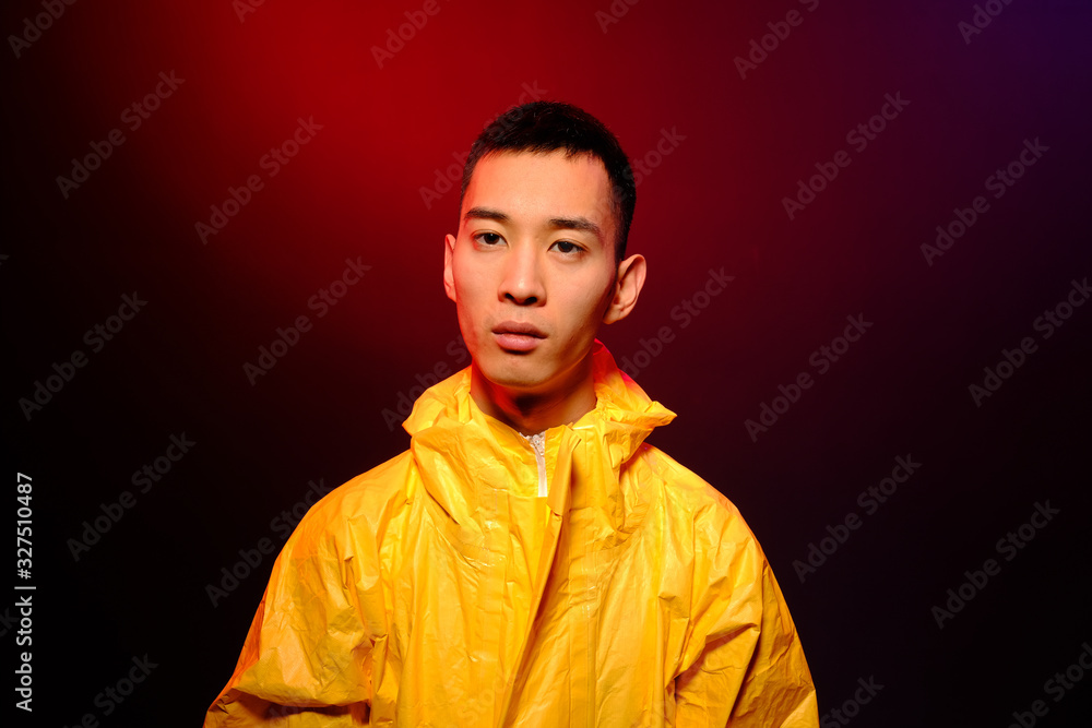 Asian man in a yellow suit of chemical protection on a colored trendy background. Conceptual fashion fashion shooting. Asian man in a yellow suit of chemical protection on a colored trendy background. Conceptual fashion fashion shooting.