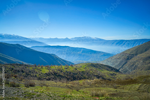a view of mountains covered with snow in the fall season in  the north of Iraq Kurdistan Region with green landscape and trees in the foreground