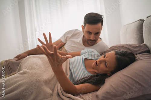 Young couple is arguing in bed.