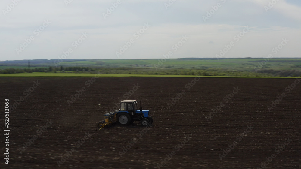 Aerial view of farm machine plowing the land Aerial view of farm machine plowing the land