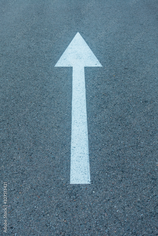 A white arrow going straight on the asphalt A white arrow going straight on the asphalt