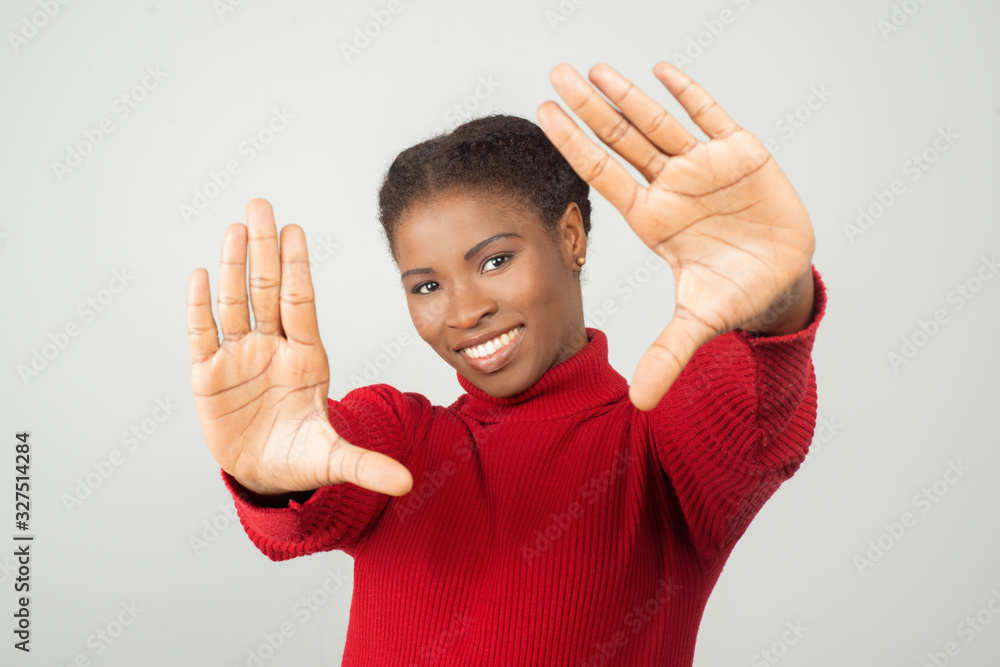 Smiling African American woman making photo frame with hands. Cheerful young lady making focus framing gesture. Creativity and photography concept Smiling African American woman making photo frame with hands. Cheerful young lady making focus framing gesture. Creativity and photography concept