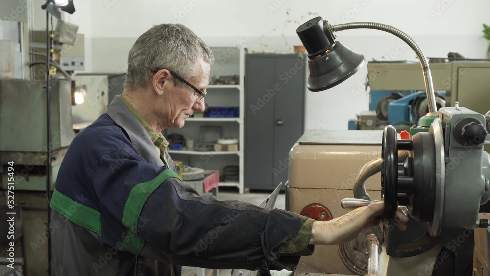 Old man working in an industrial factory on EDM Old man working in an industrial factory on EDM