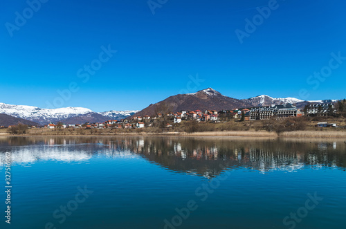 Scenic View of Lake by Mountains against Clear Blue Sky