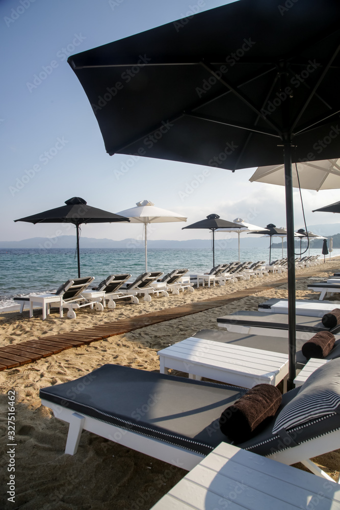 Luxurious sunbeds and umbrellas on a sandy beach