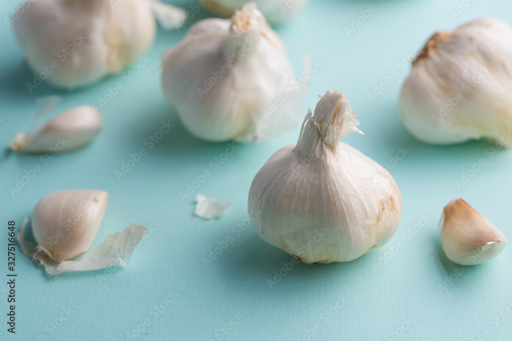 A lot of garlic on a light blue background. Close up, horizontal photo A lot of garlic on a light blue background. Close up, horizontal photo