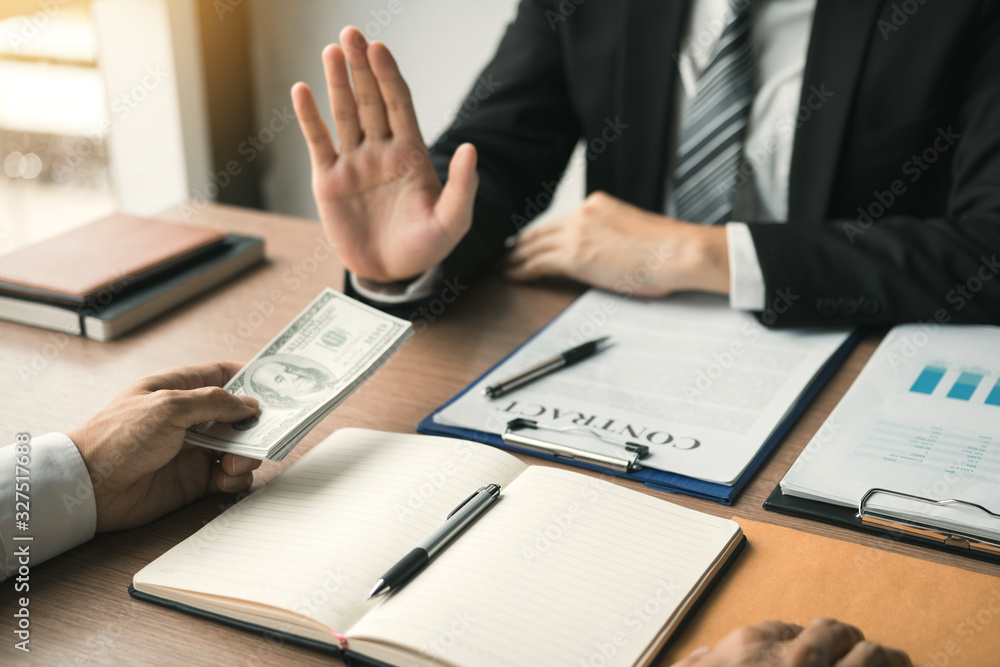 Business person refusing bribe given money by partner with anti bribery corruption concept. Business person refusing bribe given money by partner with anti bribery corruption concept.