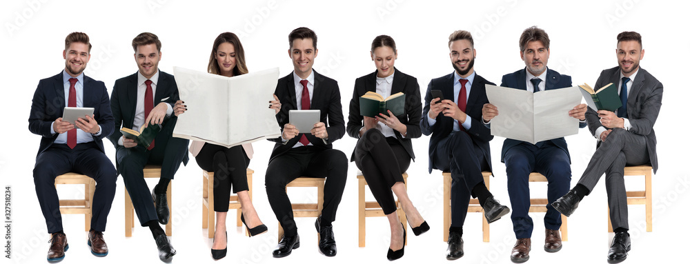8 businessmen reading from tablet, phone, book and newspaper