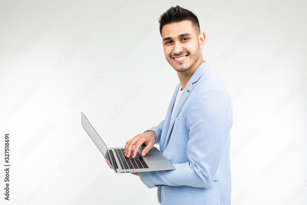 young attractive businessman is typing a message on a laptop on a white studio background young attractive businessman is typing a message on a laptop on a white studio background