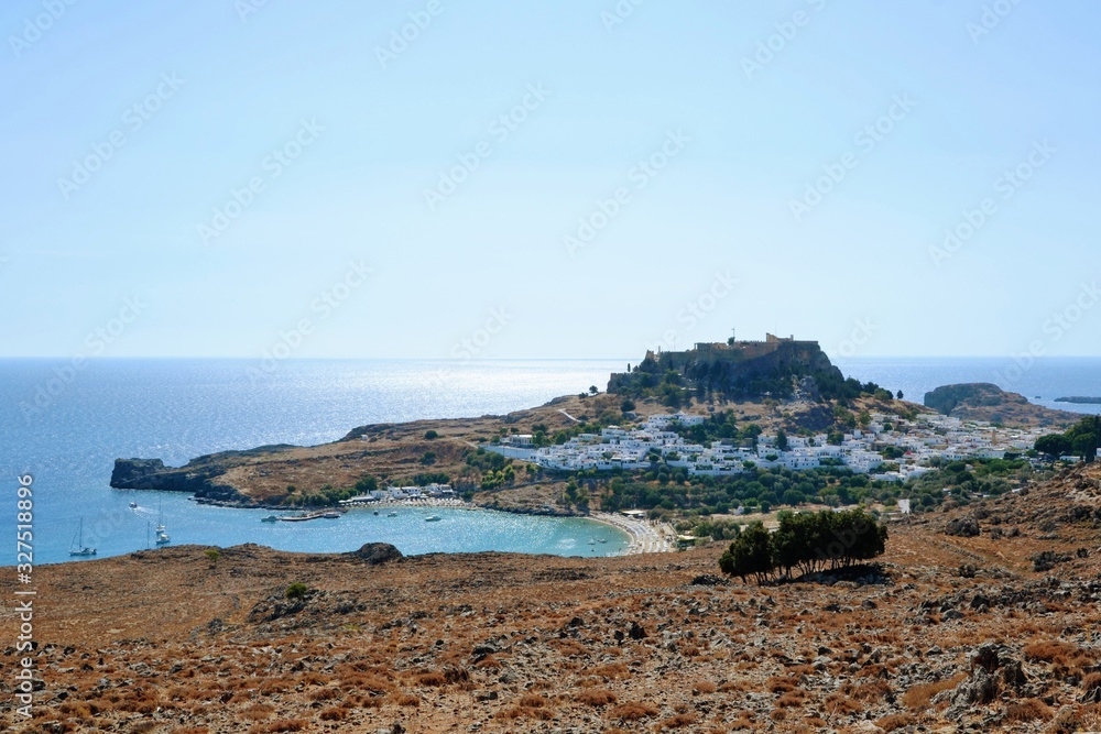 Lindos, Rhodes, Greece. Overview of Lindos. Spectacular view to the beach, Lindos village and the Acropolis of Lindos with temple of Athena Lindia