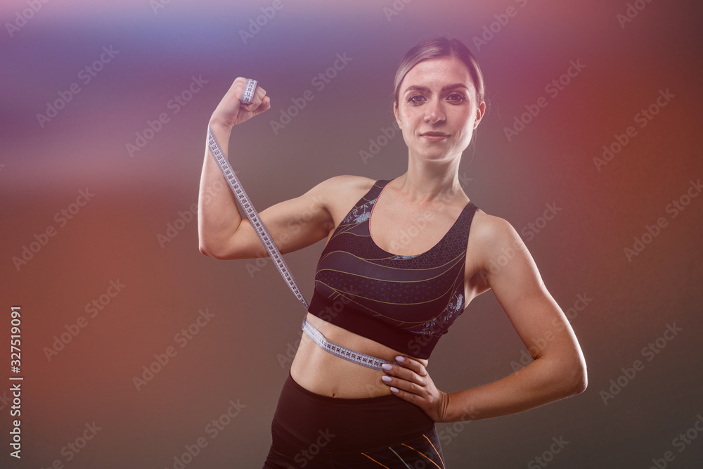 Sport caucasian girl with slim figure do exercises with sport tape isolated on black background Sport caucasian girl with slim figure do exercises with sport tape isolated on black background