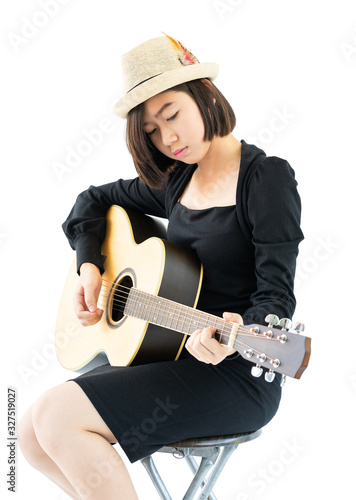 Woman sitting and playing guitar guitar folk song in her hand