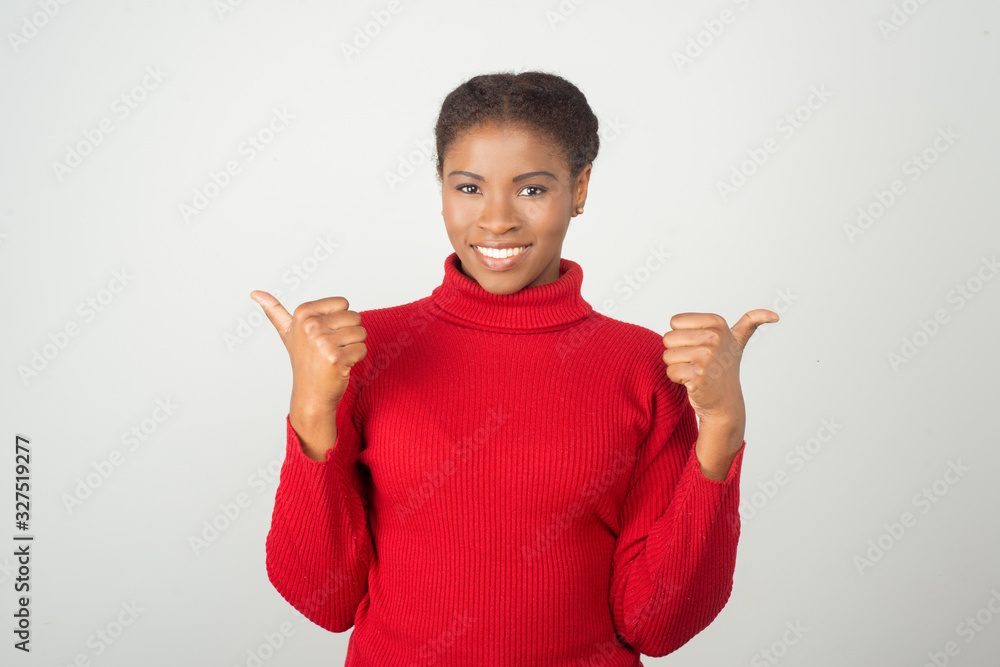Beautiful smiling woman pointing with thumbs to left and right. Cheerful lady looking at camera. Direction concept Beautiful smiling woman pointing with thumbs to left and right. Cheerful lady looking at camera. Direction concept