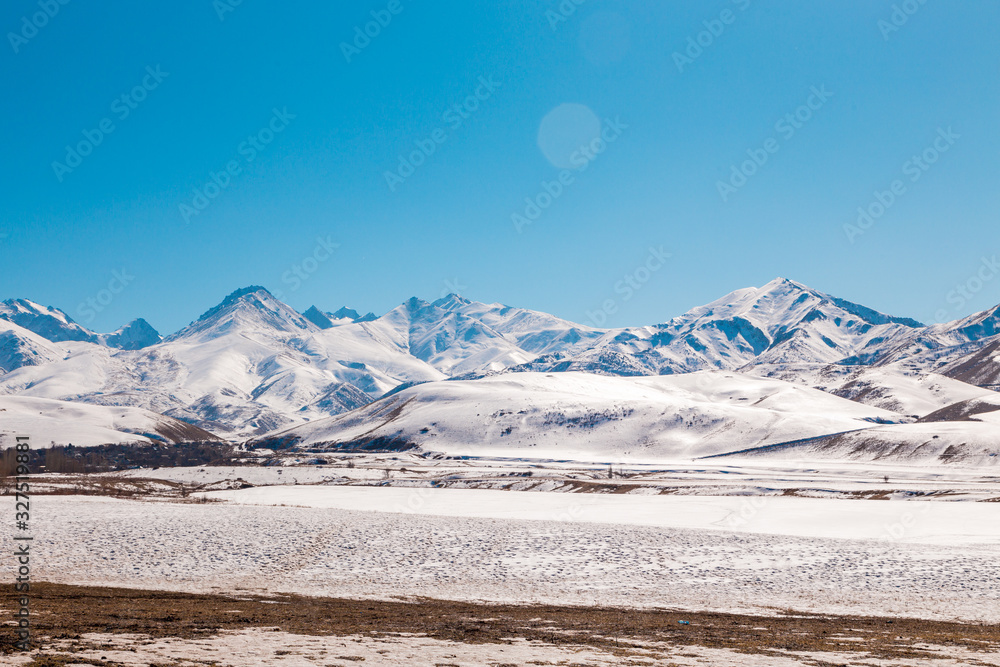 Mountains with melting snow. The end of winter, the beginning of spring. Kyrgyzstan