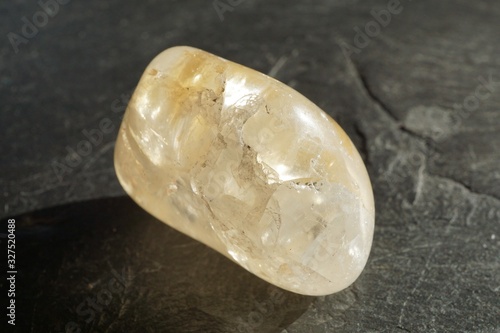 Obraz na plátně Heat-treated amethyst tumbled pebble on gray slate background
